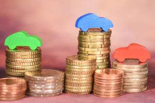 © Jean-Luc - Adobe Stock.com Foto: Geldmünzen und Holzautos